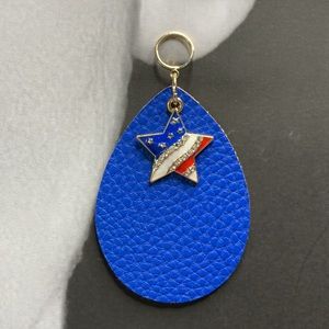 Star Flag Pendant Red White and Blue resting on Faux Leather Dangles From Stud